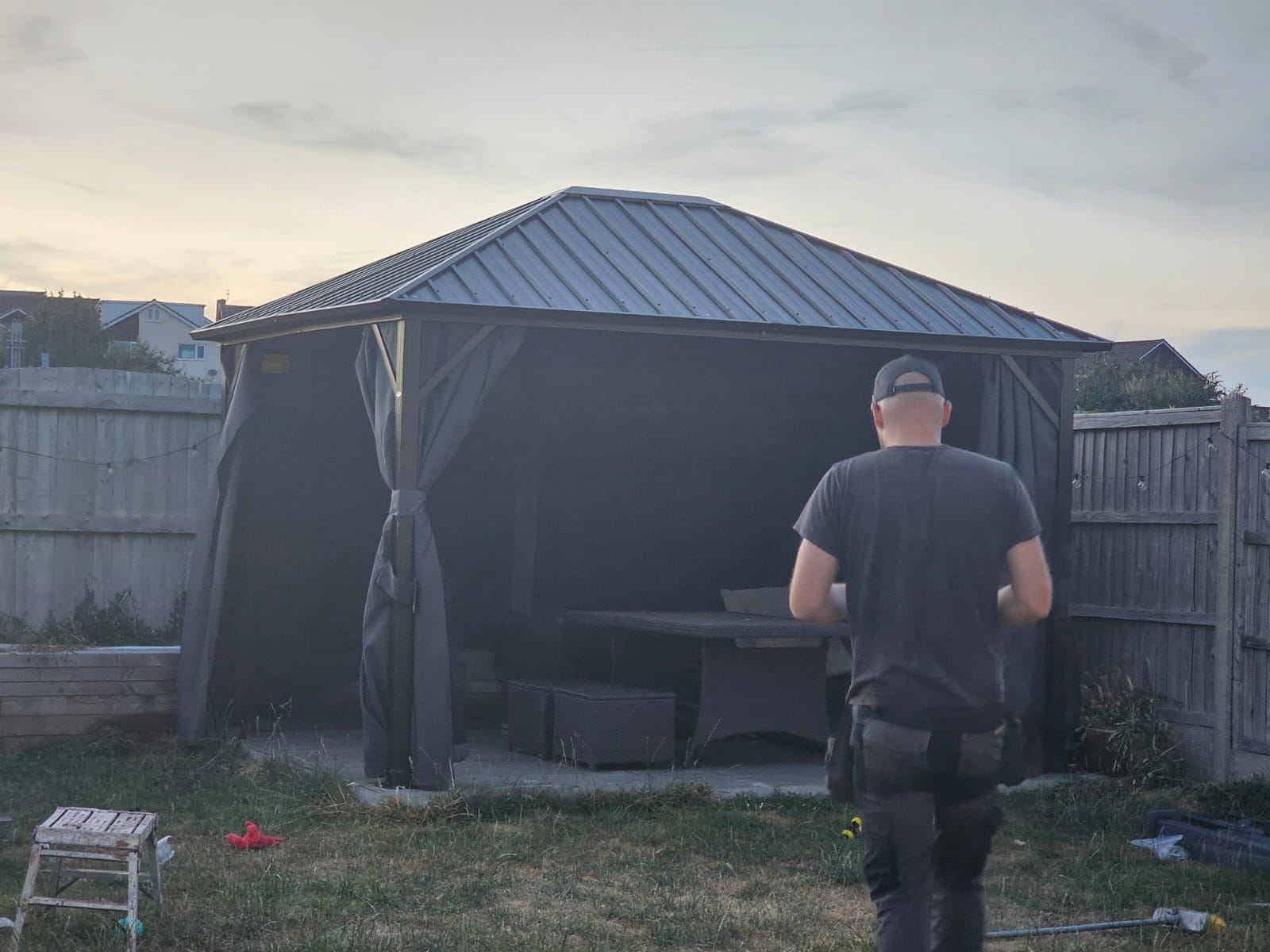 Finished metal-roof gazebo over a paved seating area — South Wales garden installation