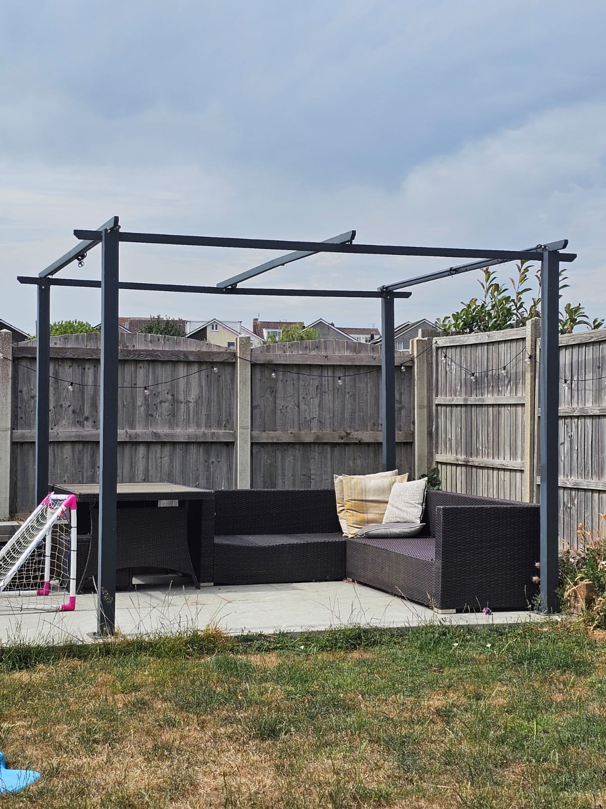 Assembled steel pergola over patio seating — Newport garden structure install