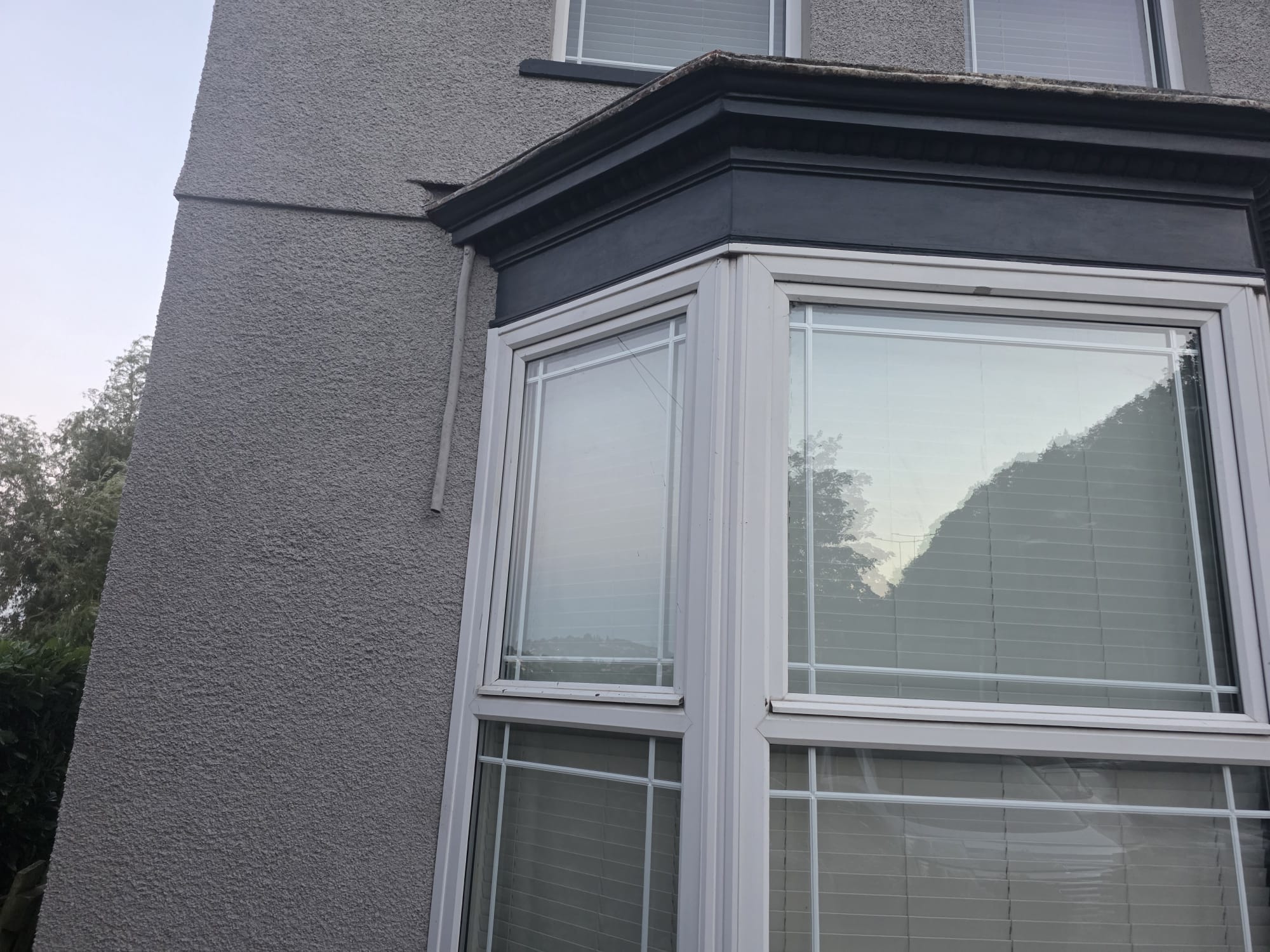 Completed window trim and rendered wall after exterior repaint — Newport