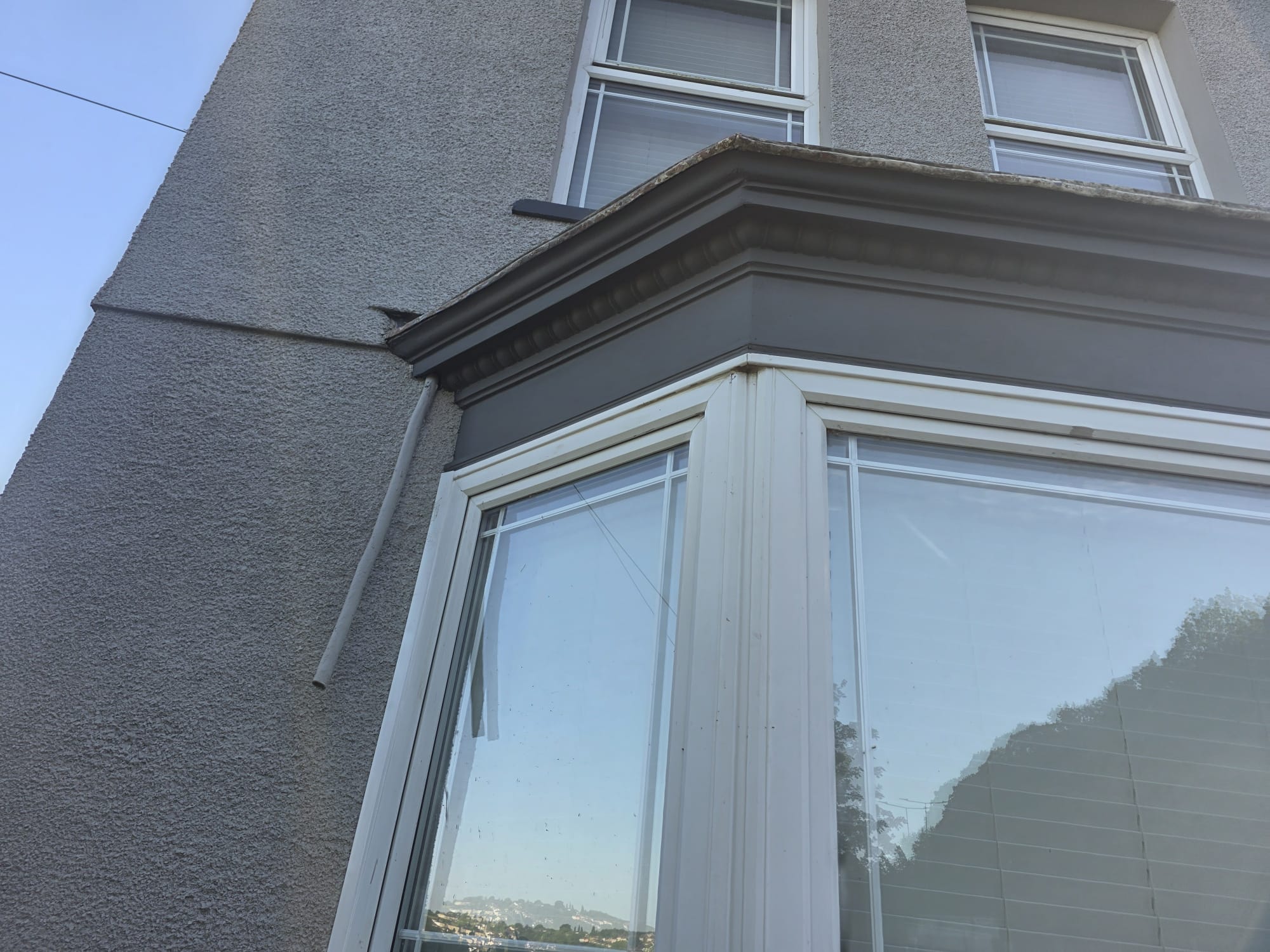 Angled view of completed dark grey window painting — South Wales